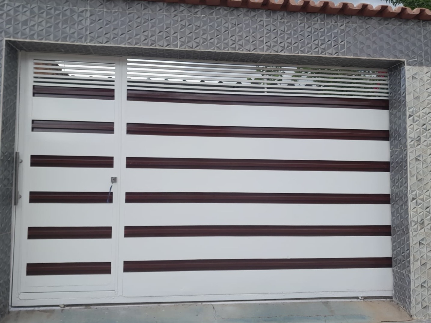 Portão de correr branco com frisos em vinho e venezianas superiores